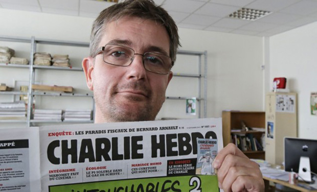 Publishing director of the satyric weekly Charlie Hebdo, Charb, displays the front page of the newspaper as he poses for photographers in Paris (Photo: AP) Publishing director of the satyric weekly Charlie Hebdo, Charb, displays the front page of the newspaper as he poses for photographers in Paris (Photo: AP)